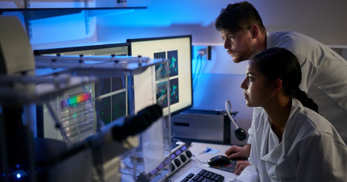 Two healthcare provider in a dark room looking at a screen
