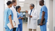 Health care clinician consulting with staff