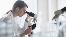 Technician looking into a microscope