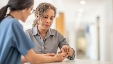 A healthcare provider speaking to an individual in a clinical setting