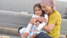 
  Person and child embracing while sitting on the floor
