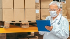 
  Healthcare provider looking at a document with boxes behind them
