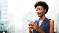 Women standing on a street looking at her phone