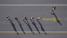 People walking in a line with one person walking elsewhere