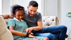
  A child setting up a smartwatch with a parent

