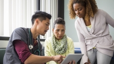 
  A provider showing a patient and their family member information on a tablet
