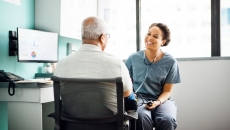 
  A provider talking to a patient while taking his blood pressure. 
