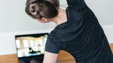 
  A person following a video stretch routine on their laptop

