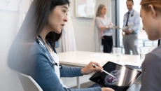 
  Two people looking at a tablet with an ultrasound image of a brain on the screen
