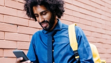 Man walking while looking at a phone