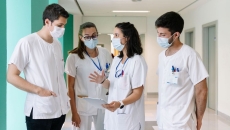 
  Healthcare workers standing in a hallway talking
