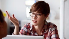 Person on a laptop speaking with someone and wearing glasses