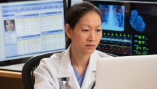A doctor reviewing a patient's record on a laptop computer