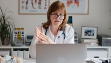 A doctor using a laptop for a virtual consultation