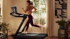 A woman running on a Peloton treadmill