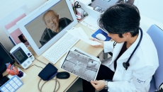 Doctor consults x-ray scans while on video call with a patient
