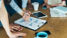 A close up of workers analyzing financial charts