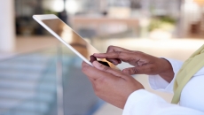 A close up photo of a woman using a tablet.