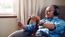 An older man using a smartphone at home.