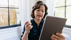 A  woman talking to a provider using a tablet