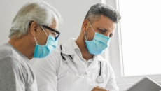 An older man and his doctor looking at a tablet
