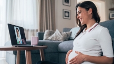 A pregnant person talking to a provider through a video chat on her laptop.