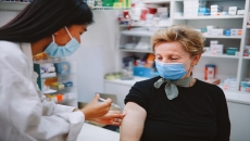 A healthcare provider giving an older woman a vaccine.