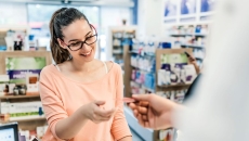Person at a pharmacy handing someone a piece of paper