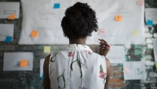 Person looks at plans posted on office wall