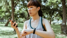 Person outdoors looks at smartphone
