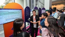 Attendees of Synapxe's first AI conference at a booth