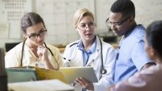 Healthcare professionals reviewing patient chart on a tablet computer
