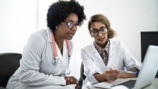 Two people sitting down and looking at a computer