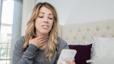 A woman participates in a telemedicine visit via smartphone
