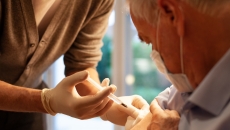 Healthcare practitioners administering injection to patient