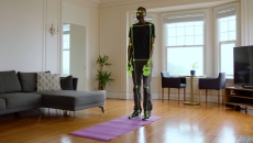 A man standing on a yoga mat while computer vision monitors his movement