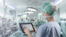 Surgeon in operating room looking at tablet