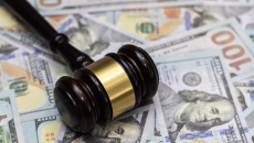 A gavel lying on a pile of money