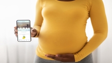 A pregnant women holding a smartphone with the PALS app
