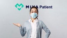 A patient model wearing mask poses behind MiyaPatient