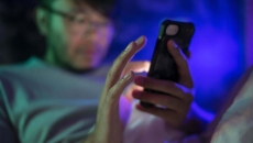 A man using a smartphone at night.