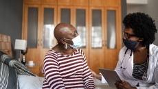 A cancer patient talking to a provider in her home.