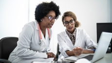 Doctors using a laptop to join a digital conference.
