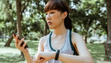 A person using a fitness tracker and mobile app to monitor her health goals