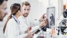 Healthcare providers in a laboratory looking at a computer