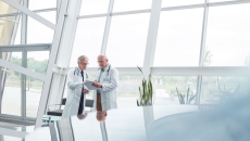 Two healthcare providers in a room with big windows