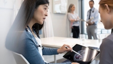 A physician showing a patient their brain scan through a mobile tablet