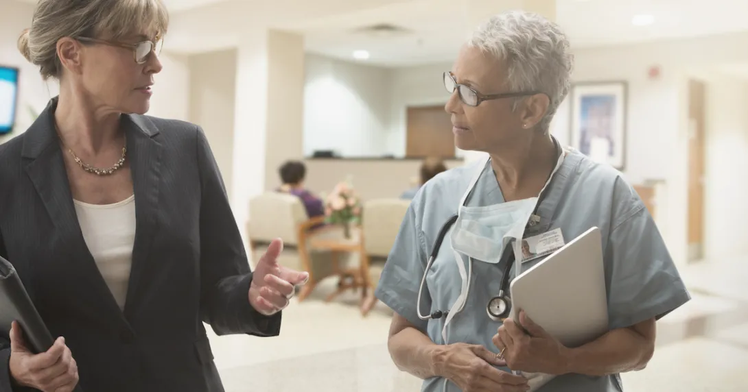 Two people in a clinical setting walking together Two people in a clinical setting walking together