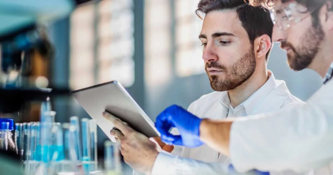 
  Healthcare workers looking at a tablet in a lab
