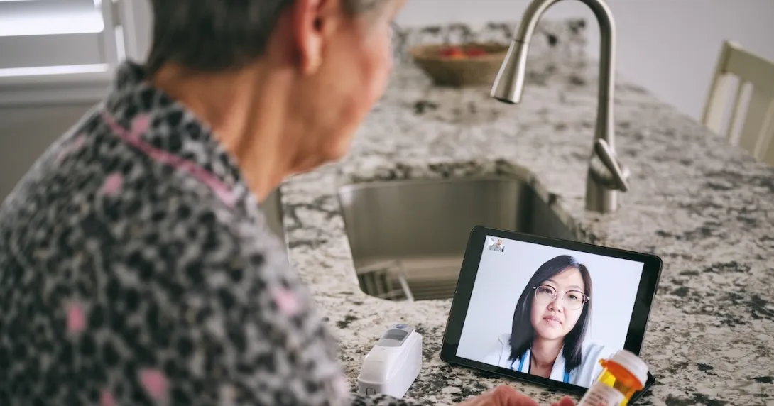 Person interacting with healthcare professional via tablet Person interacting with healthcare professional via tablet